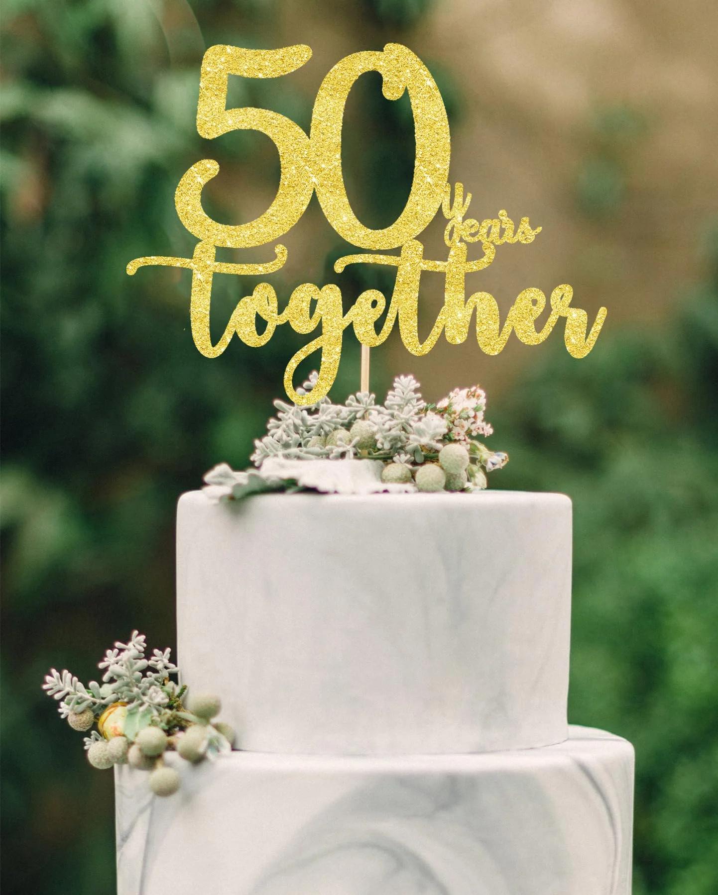 Elegant 2-tier white marble fondant cake with a gold glitter 50 Years Together topper and succulent floral accents.