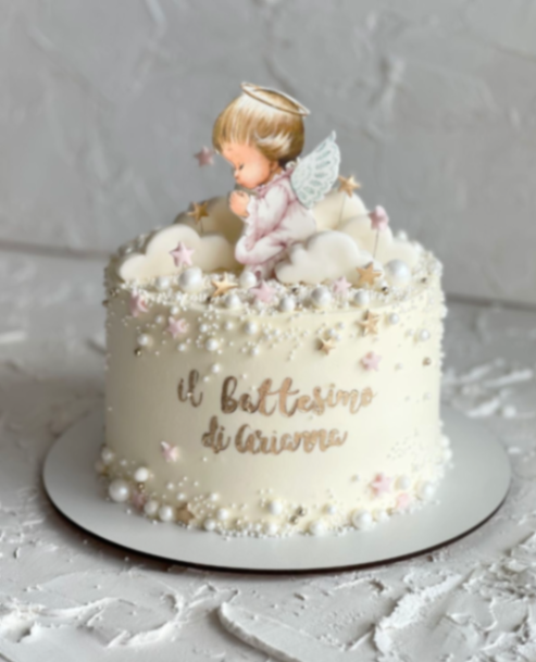 White baptism cake for Arianna featuring a praying angel printout, fondant clouds, and pearl sprinkles.