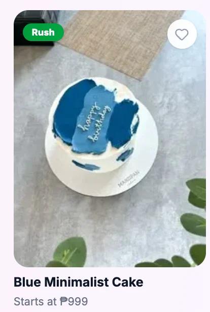 Minimalist white cake with a textured navy blue palette knife icing design on top and side, featuring a white piped happy birthday message.