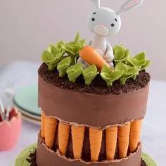 Chocolate brown fondant cake with a 3D bunny topper holding a carrot, featuring a unique carrot-filled center layer and green leaf accents.