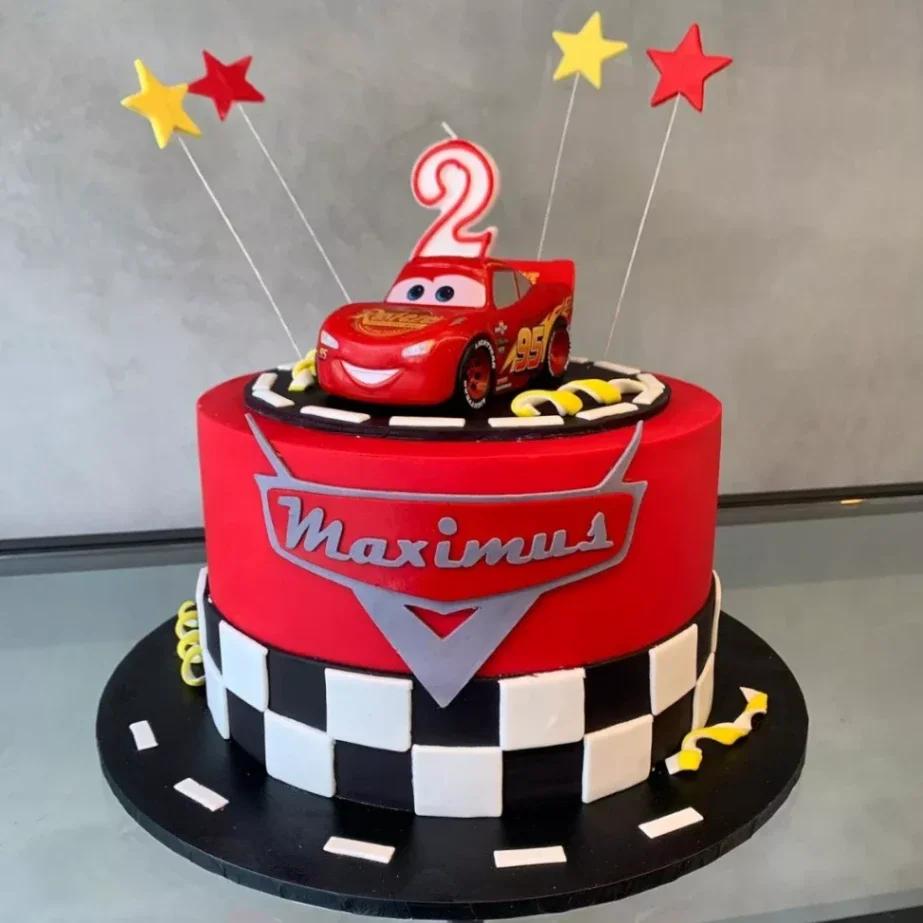 Red Disney Cars Lightning McQueen themed birthday cake with checkered pattern and star toppers.