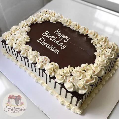 Rectangular chocolate drip cake with white icing rosettes and a Happy Birthday Ebrahim message.