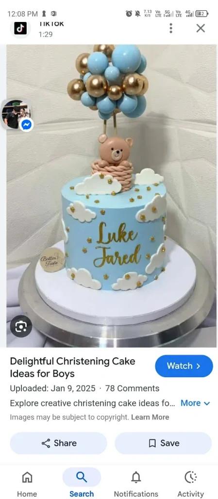 Light blue christening cake for boys featuring a 3D fondant bear in a hot air balloon basket with blue and gold balloon toppers and white clouds.