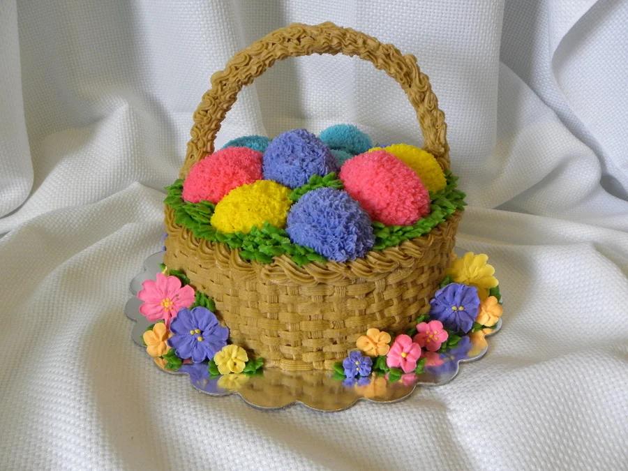 Easter basket cake with colorful piped icing eggs and a woven basket texture with floral accents