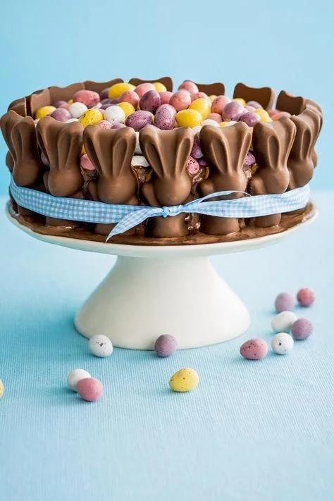 Chocolate Easter cake decorated with milk chocolate bunny figures around the sides and topped with colorful pastel candy eggs.