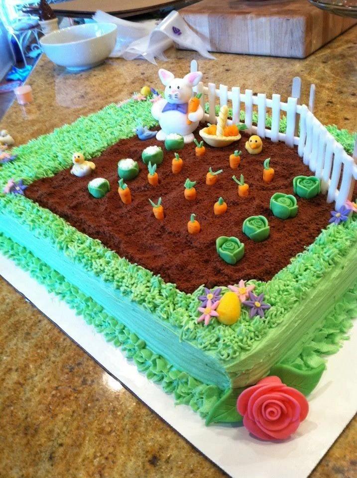 Rectangular garden themed cake with a fondant bunny, carrots in a dirt patch, and a white picket fence.