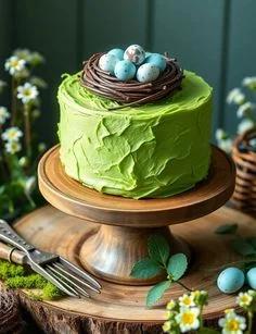 A single tier green cake with a textured icing finish, topped with a chocolate nest filled with blue and white speckled eggs.