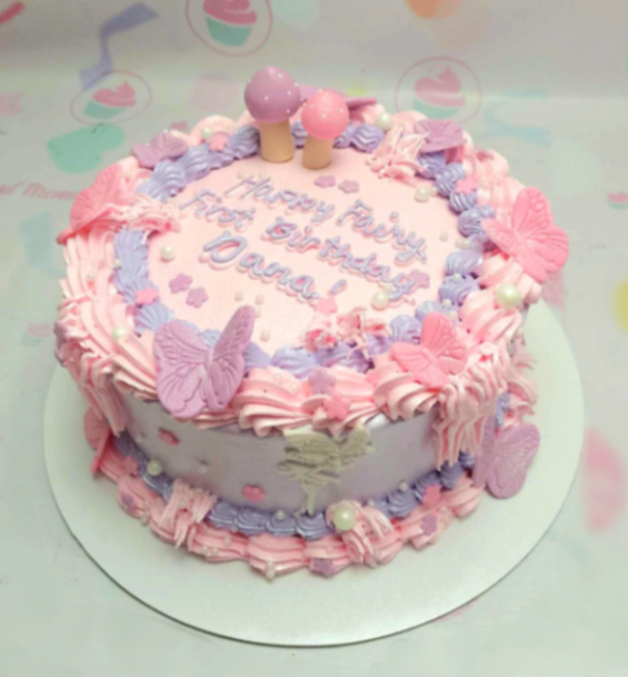 Pink and lavender fairy themed birthday cake with butterfly decorations and mushroom toppers.