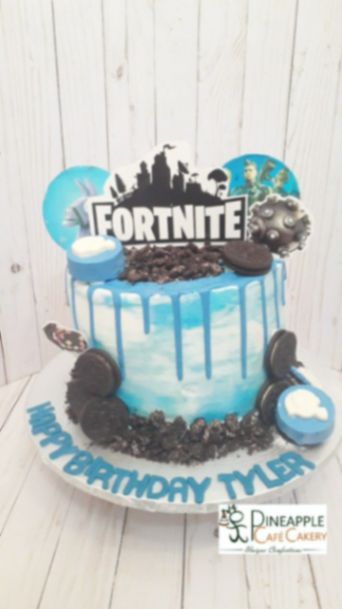 Blue and white marble Fortnite birthday cake with blue drip, Oreo cookies, and character printouts.