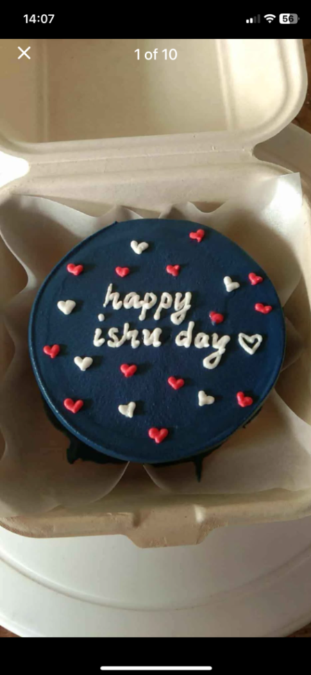 Navy blue bento cake with white and red piped icing hearts and 'happy ishu day' message