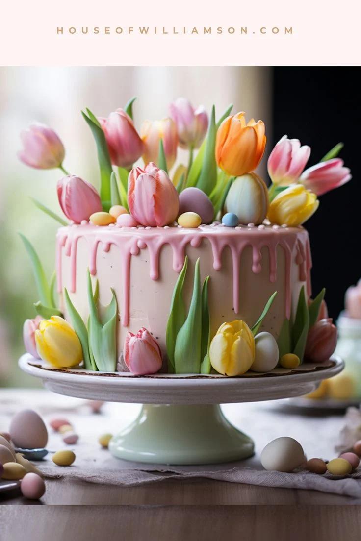 A single-tier peach cake with pink icing drips, decorated with colorful edible tulips and pastel eggs for an Easter or spring celebration.