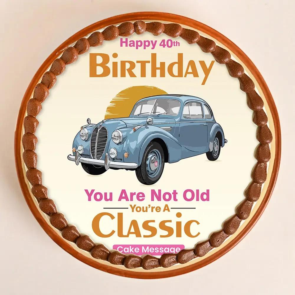 Round white birthday cake with a vintage blue car printout and brown icing border for a 40th birthday celebration.
