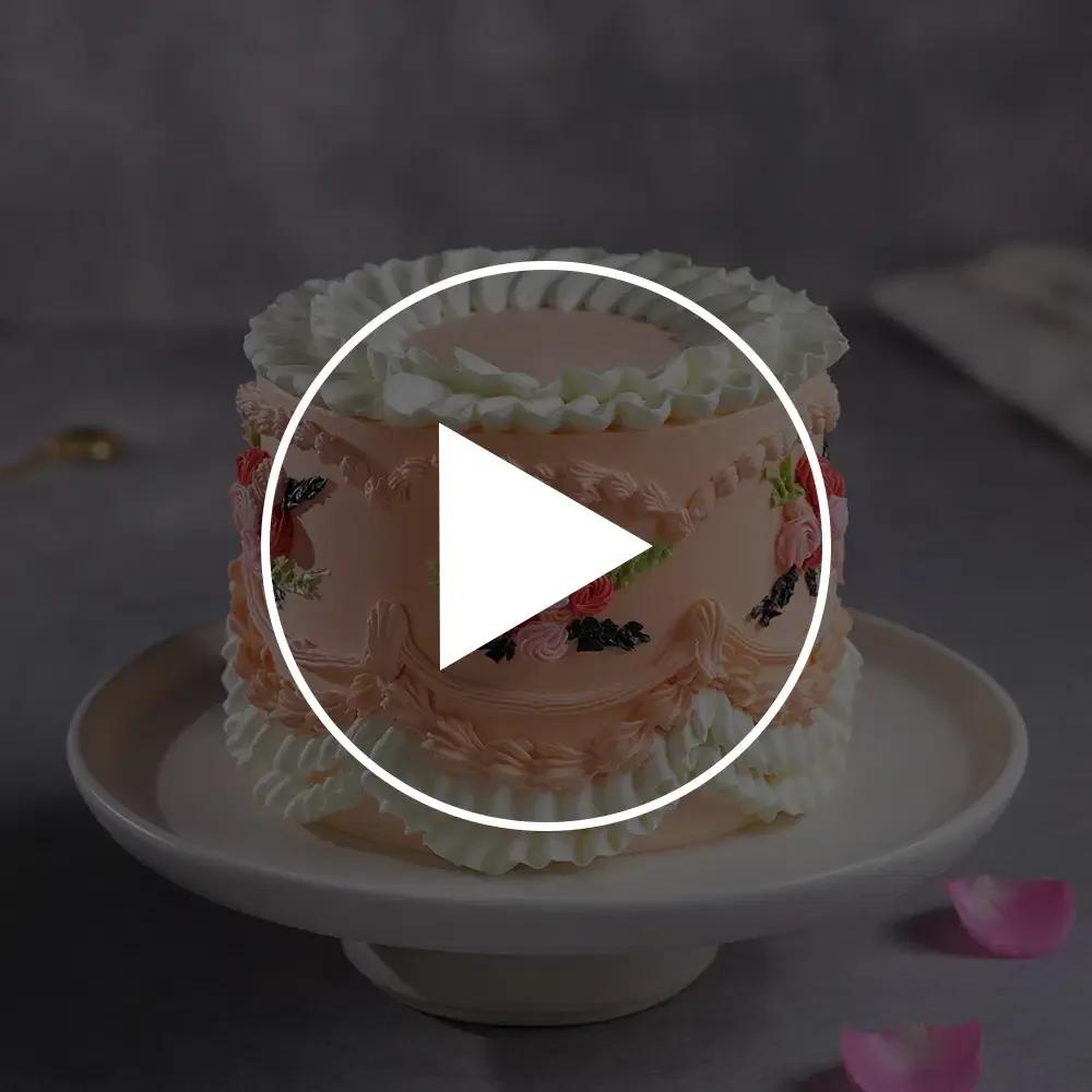 Elegant peach-colored vintage cake with intricate white and peach ruffles, piped floral garlands, and delicate icing rosettes.